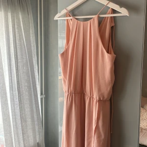 Ljusrosa klänning - Superfin ljusrosa långklänning med smala axelband och markerad midja.