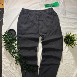 Mörkgrå mjukisbyxor Polo Ralph Lauren - Mörkgrå mjukisbyxor från Polo Ralph Lauren med broderad logga på vänster ben. Byxorna har resår och snörning i midjan samt sidofickor. Tillverkade i mjukt material som känns riktigt skönt mot huden. Perfekta för chill dagar.