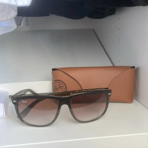 Ray-Ban boyfriend bruna solglasögon - Snygga Ray-Ban boyfriend solglasögon med brunt, lätt transparent båge och bruna tonade glas. Klassisk fyrkantig form och diskret Ray-Ban-logo på skalmen. Kommer med original brunt fodral i läderlook. 