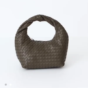 Flätad brun grön handväska i skinn - Snygg brun grön handväska med flätad design och rundad form. Väskan har ett brett handtag och är tillverkad i skinn, vilket ger en lyxig känsla. Perfekt för dig som vill ha en trendig och stilren accessoar. Aldrig använd💗