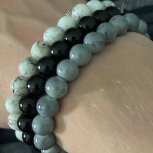 Set med pärlarmband i tre färger - Säljer ett set med tre elastiska armband av runda pärlor i svart, grått och vitmarmorerat. Perfekta att mixa och matcha för en stilren vibe. Passar både ensam eller tillsammans för en cool layering-effekt. Inget märke, men riktigt snygga och trendiga.