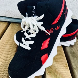 Snygga svarta sneakers från Bsat! - Snygga och sköna svarta sneakers med röda detaljer i storlek 44 från Bsat. I mycket gott skick!