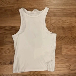 Vit ribbad linnetopp från H&M - Säljer en klassisk vit ribbad linnetopp från H&M i storlek 158/164. Toppen har breda axelband och rundad halsringning, perfekt att styla med jeans eller shorts. Tillverkad i mjuk bomull för en skön känsla hela dagen.🥰