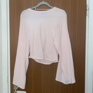 Ljusrosa långärmad topp från 157 - Säljer en ljusrosa långärmad topp från 157. Toppen har en enkel och clean design med rund halsringning och lite lösare passform. Perfekt att matcha med jeans eller kjol för en chill look. Materialet känns mjukt och skönt mot huden.