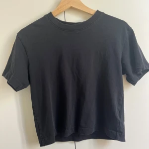 Svart t-shirt från Gina Tricot XS - En svart basic t-shirt från Gina Tricot, basically basics-kollektionen. Modellen har rund halsringning, korta ärmar och är tillverkad i mjuk bomull. Perfekt till jeans eller kjol för en enkel och clean look. Har två så den används inte❣️❣️