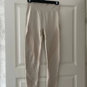 Beige seamless leggings - Snygga beige seamless leggings med ribbade detaljer längs sidorna och benen. Hög midja och tight passform som sitter skönt och följsamt. Perfekta för träning eller chill, i mjukt och stretchigt material.