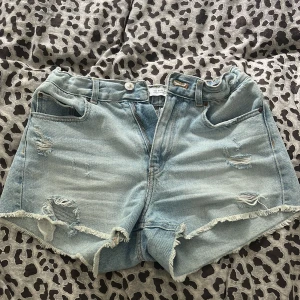 Ljusa jeansshorts med slitningar från Zara - Säljer ett par ljusblå jeansshorts från Zara, skit snygga och använt dem några gånger men då dem inte passar längre. Vet inte om man ser så tydligt på sista bilden då det är en liten flek men man ser inte det så tydligt utan bara så man vet