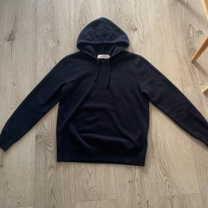 Mörkblå  cashmere hoodie från Sayless - Säljer en stilren blekblå hoodie från Sayless i mjuk cashmere. Perfekt för kyliga dagar med sin bekväma passform och klassiska design. Hoodien är i storlek XS. Killen på bilden är 175. Skriv vid minste fundering!