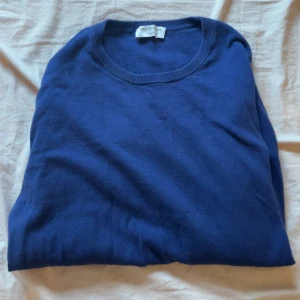 Blå tröja från Tiger of Sweden - Mörkblå, stilren tröja från Tiger of Sweden i mjuk bomulls- och kashmirblandning. Klassisk rund halsringning och långa ärmar. Inga hål eller slitningar utan bara använd. 