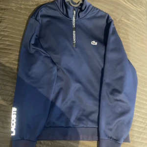  Lacoste half zip  - Snygg marinblå tröja från Lacoste med half zip. Regular fit, priset kan diskuteras vid snabb affär 