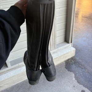 Svarta höga ridstövlar i skinn - Säljer ett par svarta höga ridstövlar i skinn med dragkedja längs baksidan från Hööks. Använda men i fint skick. Kommer torka av dom innan frakt såklart! 