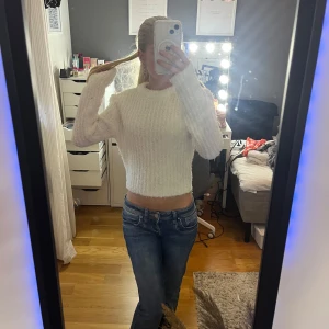 Vit stickad tröja - Supermysig vit stickad tröja. Tröjan har en rund halsringning och är fluffig i materialet, perfekt för kyligare dagar. Enkel att matcha med jeans eller kjol för en chill look.