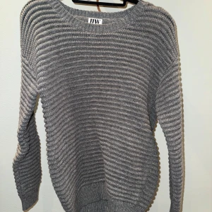 Grå ribbstickad tröja - Säljer en grå ribbstickad tröja med rund halsringning och långa ärmar. Tröjan är aldrig använd med saknar prislapp. Passformen är något stor skulle jag säga. Passar personer med storlek runt XS-M beroende på vilken passform du vill ha!