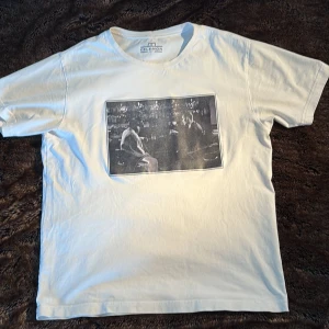Vit Celemon Tisha - Vit t-shirt från Celemon med en stor svartvit print på bröstet som föreställer två personer vid en bardisk. Liten fläck längst ner på baksidan men inget som märks. Riktigt fet tröja men bar den endast 3 gånger för länge sedan och rensar ut. Sitter perfekt på mig som är 179 65kg. Kan mötas i sthlm! 