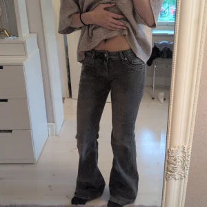 Grå bootcut jeans från H&M Divided - Snygga grå jeans från H&M Divided i bootcut-modell. Jeansen har klassisk femficksdesign, låg midja och är tillverkade i mjukt denimtyg. Perfekta för dig som gillar en avslappnad men trendig look.