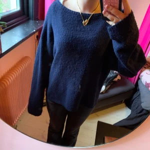 Mörkblå stickad tröja med loose fit - Mysig mörkblå stickad tröja med avslappnad passform och långa ärmar. Tröjan har en enkel design med lite bredare halsringning och känns superbekväm. Perfekt för dig som gillar en chill och stilren look.