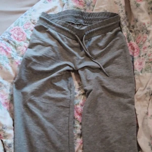 Nersydda Low-waist mjukisbyxor från Lager-157 - XS-S Säljer ett par grå mjukisbyxor med elastisk midja och snörning. Som är nersydda till att va extra lowwaist Byxorna har raka ben och är tillverkade i mjukt bomullsmaterial, perfekta för chill dagar. 