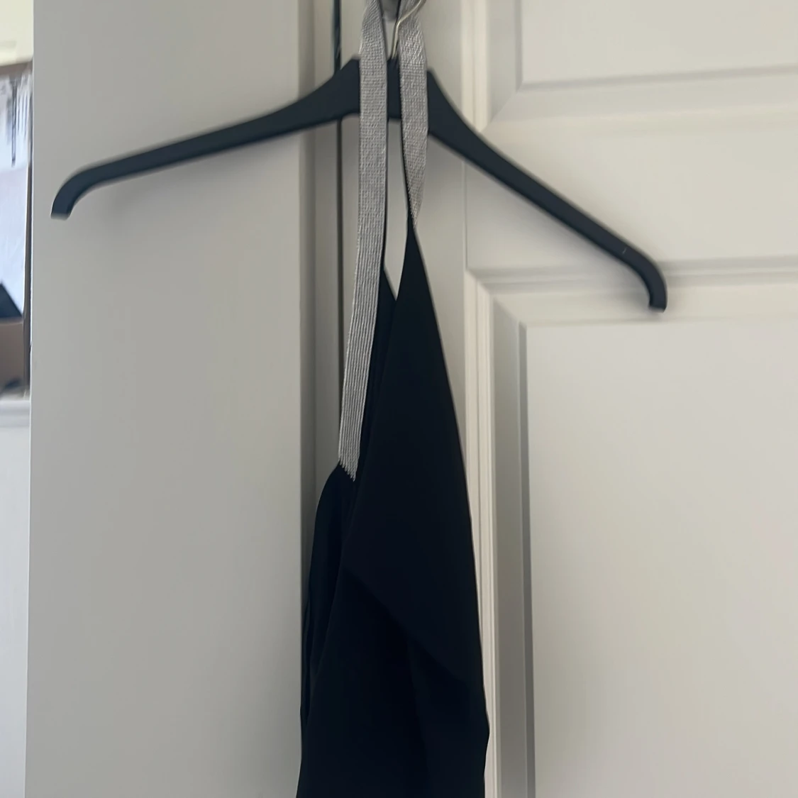 Svart festtopp med glittriga band från MNG