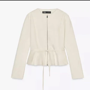 Beige mocka jacka zara - Snygg vit jacka från Zara med dragkedja framtill och knytband i midjan. Jackan har lång ärm, rund halsringning och en lätt peplum-effekt nedtill. Perfekt för dig som gillar stilrena och trendiga plagg. Slutsåld på zara!