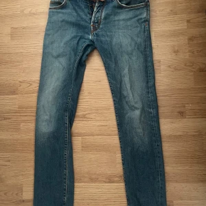 Jacob Cohën blå jeans, stl 32 - Snygga blå jeans från Jacob Cohën i klassisk modell med orange kontrastsömmar och fem fickor. Jeansen har rak passform och är tillverkade i mjukt denimtyg. Perfekta för dig som gillar stilrena och tidlösa jeans med exklusiv känsla. Har en liten reva på höger sida som knappt syns men går att få synlös men några få stygn