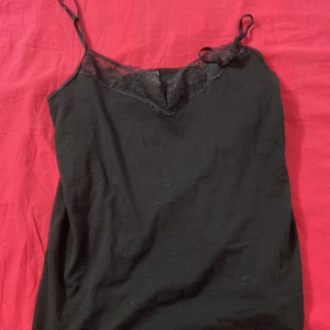 Svart linnetopp - Svart linnetopp med tunna axelband. Har aldrig använts(suttit i garderoben)