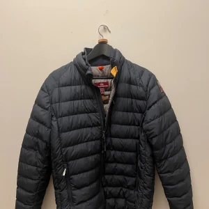 Parajumper Ugo Lightweight  - En snygg mörkblå/svart lightweight parajumper, inte så använd men säljer för att den är förstor, den har en liten defekt som syns på bild 5, därav det billiga priset, Nypris-5400 mitt pris 800. Hör av er vid funderingar!