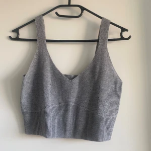 Grå ribbad linnetopp från Kay/Day xs - Snygg grå linnetopp från kappahl / Kay/Day i ribbstickad design. Toppen har breda axelband, v-ringning och är croppad. 