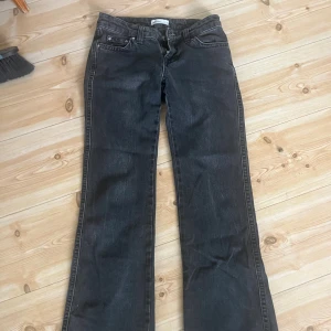 Svarta bootcut jeans från Gina Tricot - Snygga svarta jeans från Gina Tricot i storlek 34. Modellen har klassisk femficksdesign, raka ben med bootcut och silverfärgade knappar på bakfickorna. Jeansen är tillverkade i ett slitstarkt denimtyg med en mörk tvätt. Säljs då dom är lite för korta för mig som är 171cm.