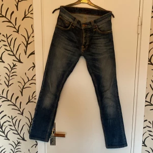 Nudie Jeans  - Säljer ett par nudie jeans i model Grim Tim i storlek 29W 32W. Byxorna är blå och har en fet fade