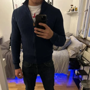 Marinblå fullzip, Polo Ralph Lauren - Marinblå stickad kofta från Polo Ralph Lauren i storlek M men passar även som S. Använd 3-4 gånger och är i väldigt bra skick, skick (9/10). Perfekt nu till hösten. Skriv om ni är intresserade🙌🏻