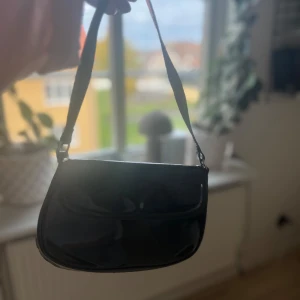 Jättefin svart väska 💓 - Jättefin väska med glansigt material💓. Köpte för ungefär 200 kr🫶.
