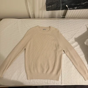 Beige stickad tröja från Zara - Säljer en stilren beige stickad tröja från Zara i storlek S. Tröjan har rund halsringning, ribbade muddar och lång ärm. Perfekt för lager-på-lager och enkel att matcha med jeans eller kjol.