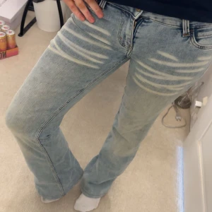 Ljusblåa Cheap Monday jeans bootcut - Säljer ett par ljusblå jeans från Cheap Monday med bootcut och slitna detaljer framtill. Bara använts 1 gång 