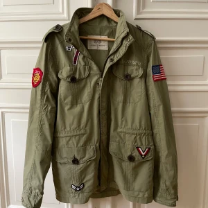 Field Jacket Adrian Hammond - Säljer en fet field jacket med massa sköna patches från Adrian Hammond. Den har ett litet hål i ena fickan men det är inget som syns, hör av er vid frågor!