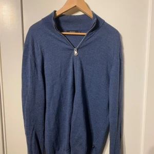 Blå merinotröja med hel zip från Matinique - Säljer en blå långärmad tröja från Matinique i 100% merinoull. Tröjan har en snygg hel zip-dragkedja vid halsen och ribbade muddar. 