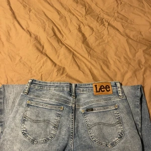 Blå Lee jeans med raka ben - Snygga ljusblå jeans från Lee med klassisk bootcut. Low waist modell och iprincip oanvända.