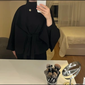 Svart poncho kappa från Nelly  - Säljer nu den populära poncho kappan från nelly som inte säljs längre. Den har använts 2 gånger och är i nyttskick❣️