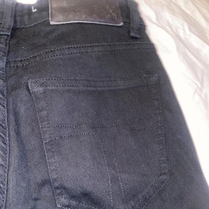 Svarta jeans från Tiger of Sweden -  svarta skinny jeans från Tiger of Sweden med klassisk femficksdesign och stilren svart läderpatch i midjan. Dem är Mid waist i midjan. Finns ingen storlek på dem men dem funkar på mig som vanligtvis är en storlek s/m