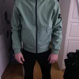 Grön regnjacka från Stone Island  - Snygg ljusgrön vindjacka från Stone Island i storlek XL men passar L. Modellen har vanligtvis L och är 188 cm. 