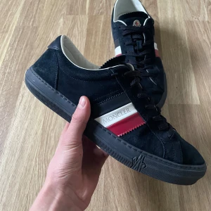 Svarta Moncler skor i mocka  - Ett par Moncler skor i svart mocka. Skorna har storlek 43 och är i fint skick. Original kartong finns inte.