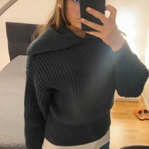 Mörk grön stickad tröja med krage från H&M - Säljer en mörk grön stickad tröja från H&M i storlek S. Tröjan har en bred, nedvikt krage och är ribbstickad med lång ärm. Modellen är lite loose och passar perfekt för dig som gillar en chill och snygg look. Superenkel att styla med jeans eller kjol.
