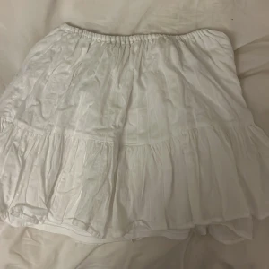 Vit volangkjol från hm - Supersöt vit kortkjol från h&m med volanger och elastisk midja. Kjolen har diskreta spetsdetaljer och små prickar i tyget. I storlek xxs men skulle säga att den är xs/s eftersom midjan är elastisk