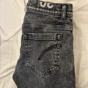 Dondup George skinny jeans svart - Snygga svarta jeans från Dondup, modell George Skinny Fit. Jeansen har en tvättad look med klassiska fem fickor och smal passform. Tillverkade i Italien med jeansmaterial som känns både slitstarkt och bekvämt. Jeansen är i toppskick. Säljer pga att dem blivit för små. Hör av er vid frågor!