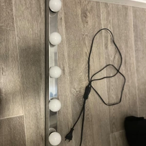 Sminkspegel LED-lampa - Elegant LED-lampa från ikea med fem ljusstarka glödlampor, perfekt för sminkspegel eller belysning vid sminkbord. Silverfärgad ram, strömbrytare på sladden och EU-kontakt. Lampan fungerar utmärkt och är i fint skick budgivning från 250kr.