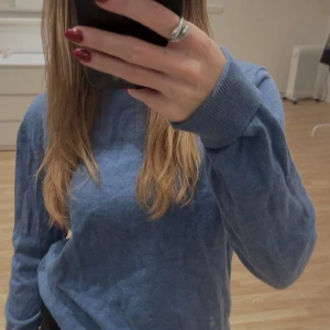 Blå stickad tröja - Snygg blå stickad tröja med rund hals och långa ärmar. Tröjan har ribbade muddar vid ärmslut och nederkant. Den är mer damm blå i verkligheten. Säljer då den aldrig har kommit till användning💙
