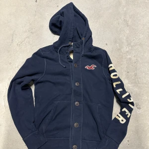 Vintage Hollister hoodie med knappar - Extremt eftertraktad och sällsynt vintage  Hollister hoodie med knappar! Grymt skick, inga defekter - ser exakt ut som på bild! Storlek M. Skriv vid frågor!💬