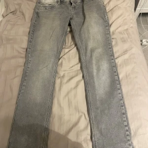 Grå straight jeans från ltb  - Snygga grå jeans från ltb med klassisk femficksdesign och raka ben. Jeansen har en ljusgrå tvätt och subtila slitningar som ger en cool vibe. Passar dig som gillar enkel stil med lite edge. Perfekt till sneakers eller boots.
