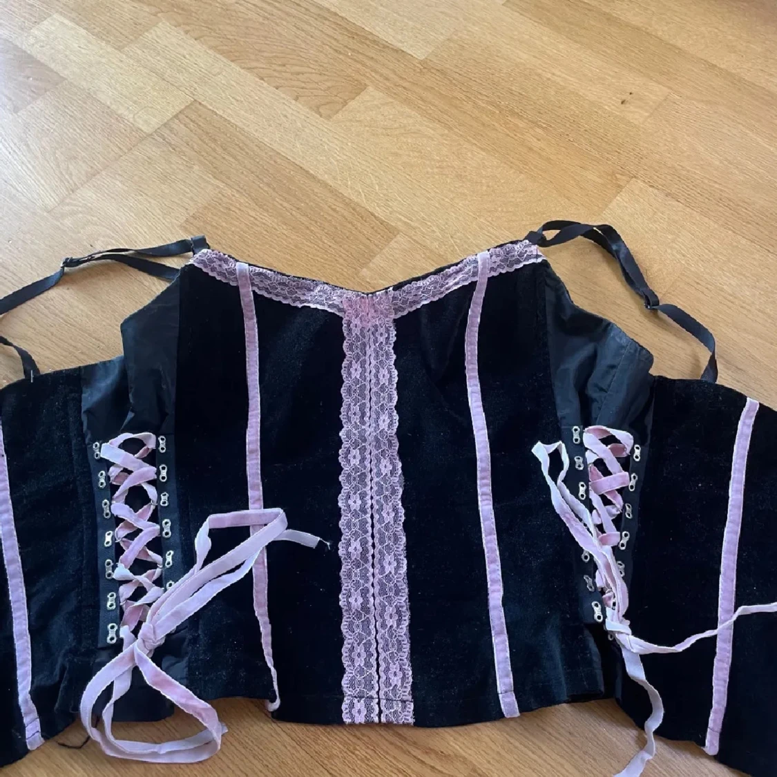 Svart korsett med rosa spets och snörning