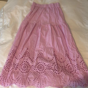 Ljusrosa långkjol med broderad spets -  ljusrosa långkjol med broderad spetsdetaljer längst ner