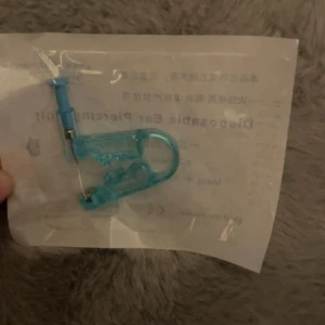 Disposable Ear Piercing Unit - Ny, engångs öronpiercingsenhet i steril förpackning. Enkel att använda, minimerar risk för infektion. Passar för säker och hygienisk öronpiercing hemma. Inga synliga defekter, obruten förpackning.